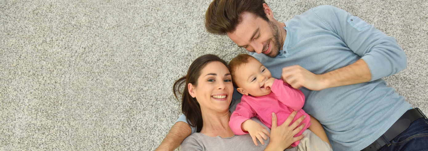 parents and baby lying on the floor