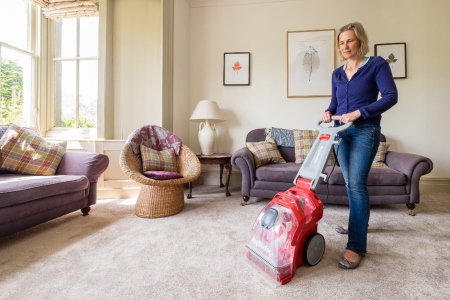 Woman using Rug Doctor machine on carpets
