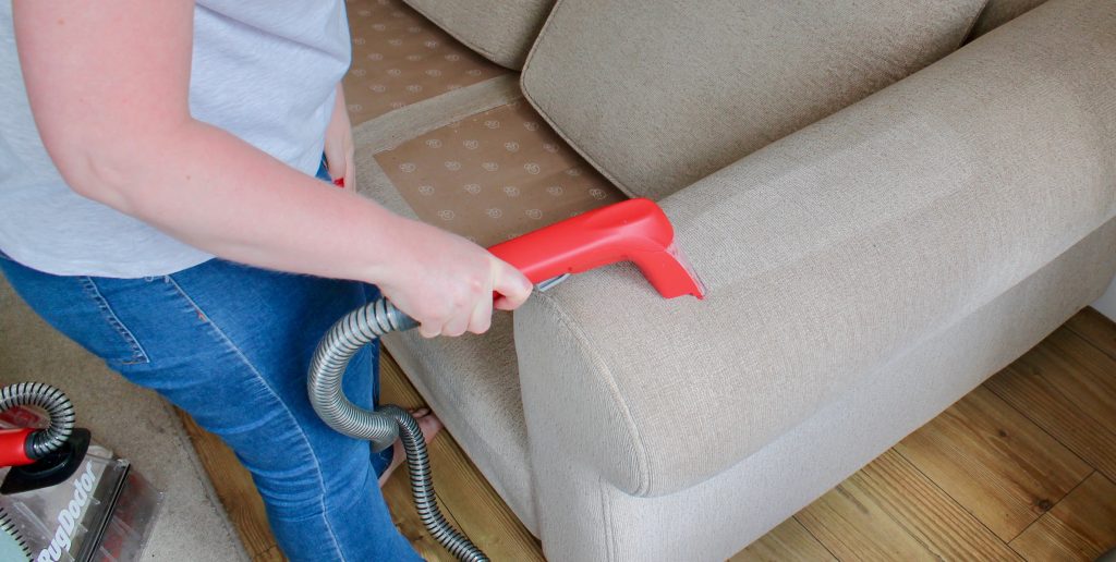 Cleaning sofa arm with hand tool attachment