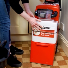 Woman attaching tank to Rug Doctor machine